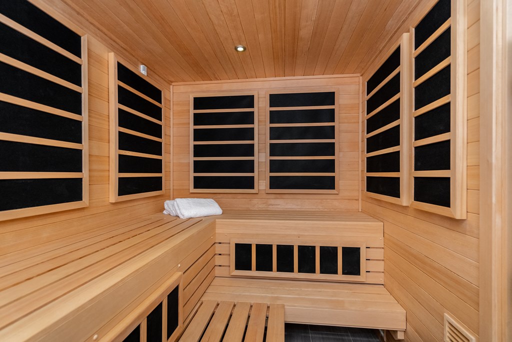 a sauna in a wood paneled room with a white towel