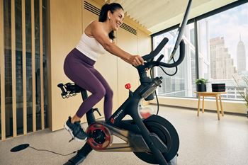 a woman riding an exercise bike in a living room