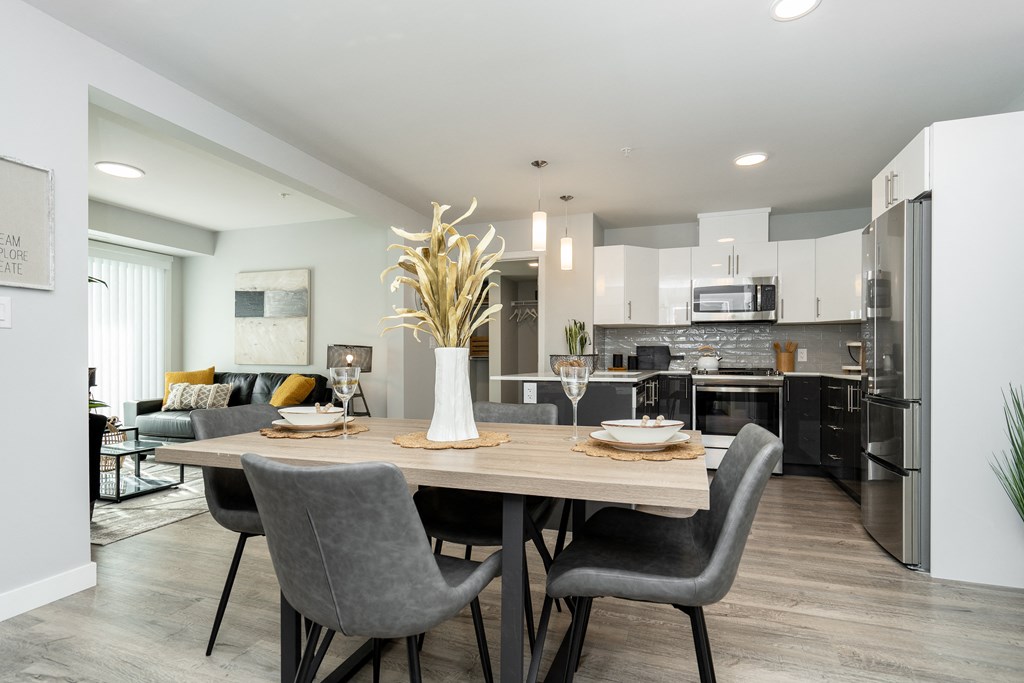a dining room and kitchen area with a table and chairs