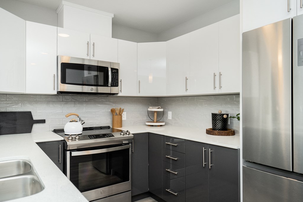 a modern kitchen with stainless steel appliances and white cabinets