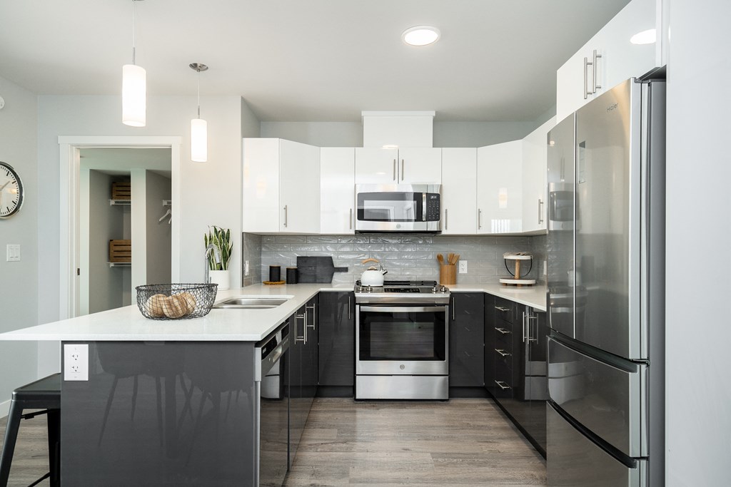 a modern kitchen with stainless steel appliances and white cabinets