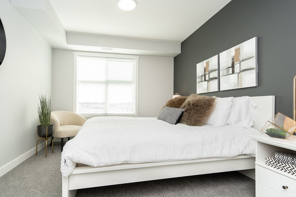 a bedroom with a large white bed and a window