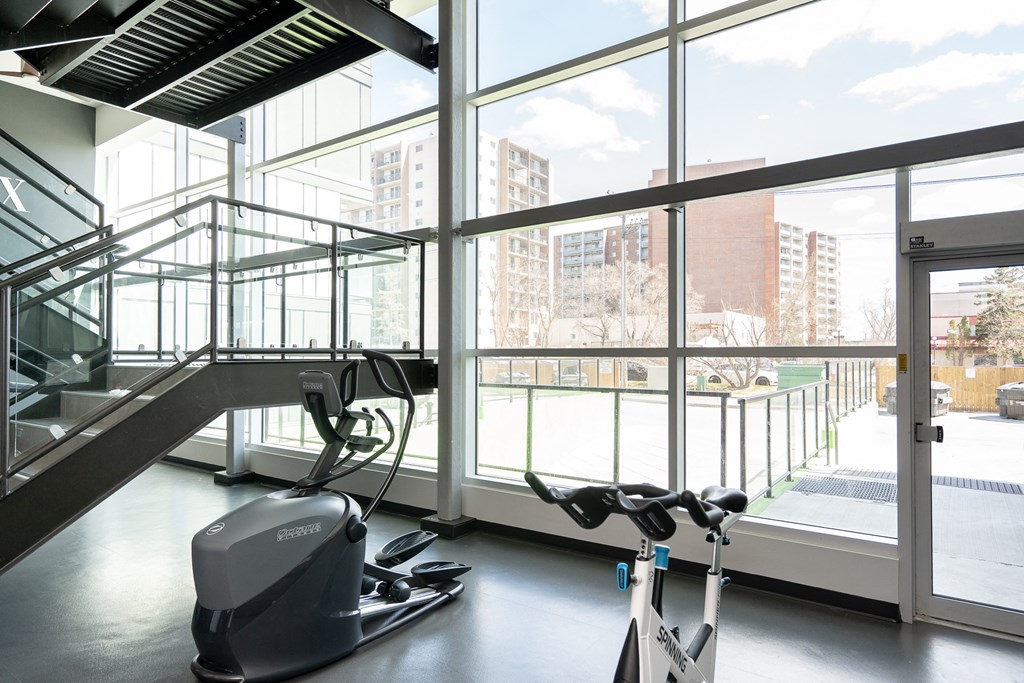 a gym with a lot of windows and exercise equipment