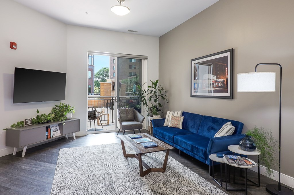 A living room with a blue couch and a flat screen TV.