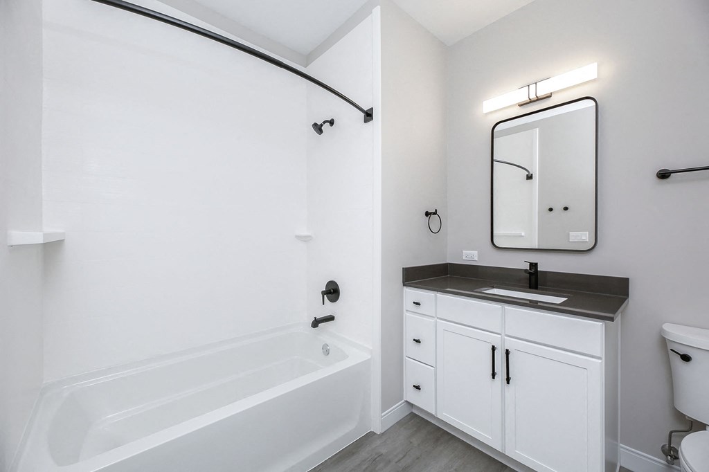 a white bathroom with a sink and a bath tub