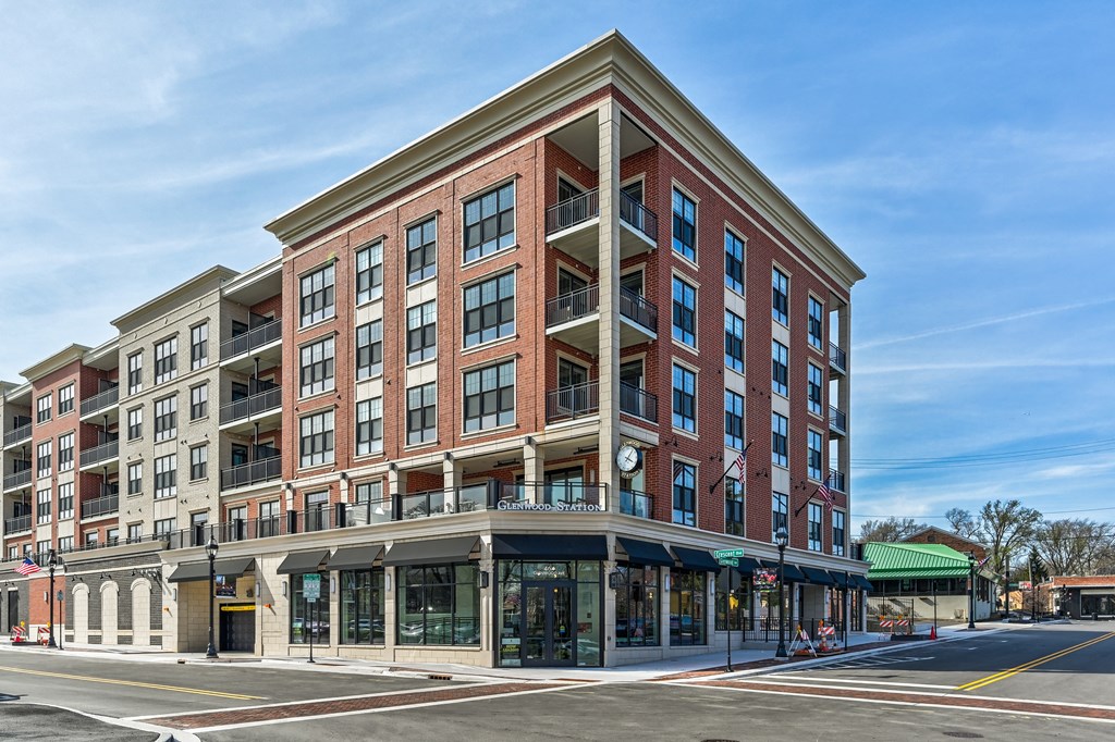 A large red brick building with a green awning on the corner.
