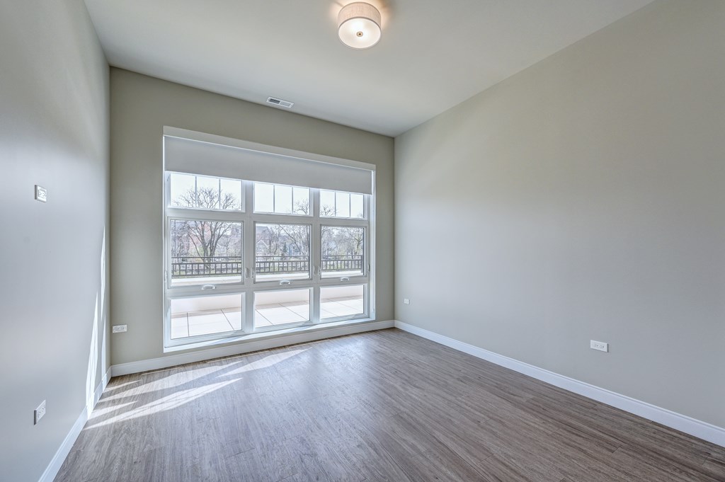 A room with a large window and wooden flooring.
