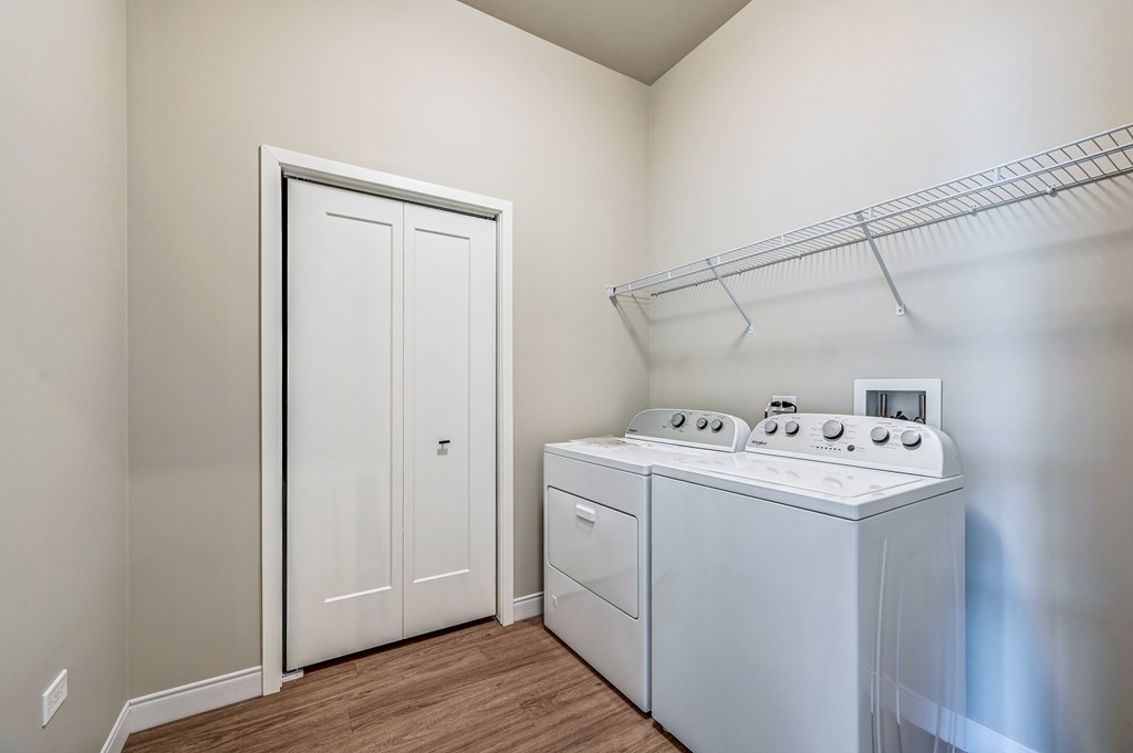A white door is in a room with a white oven and a white stove.