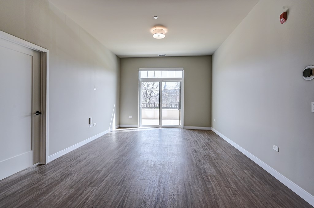 A room with a wooden floor and a large window.