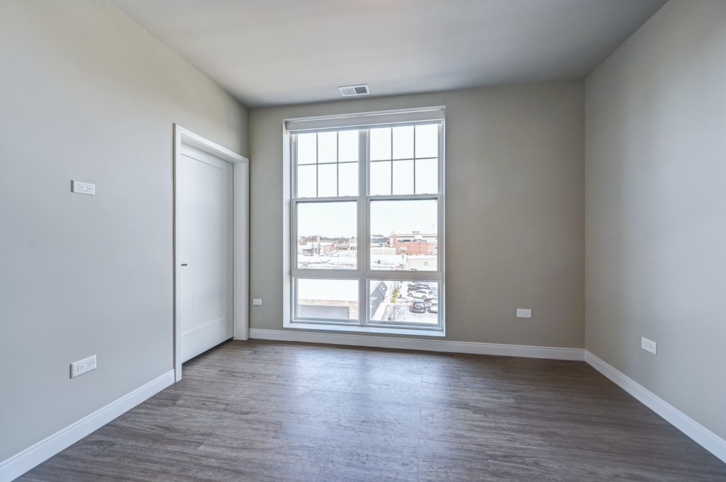 A room with a large window and a view of the city.