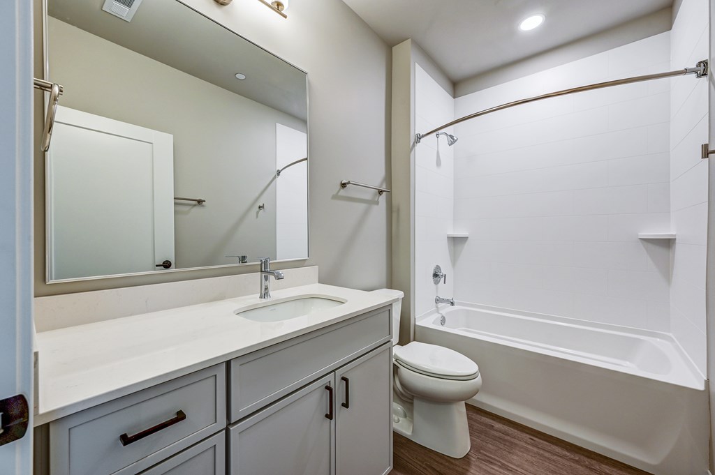 A white bathroom with a sink, toilet, and bathtub.
