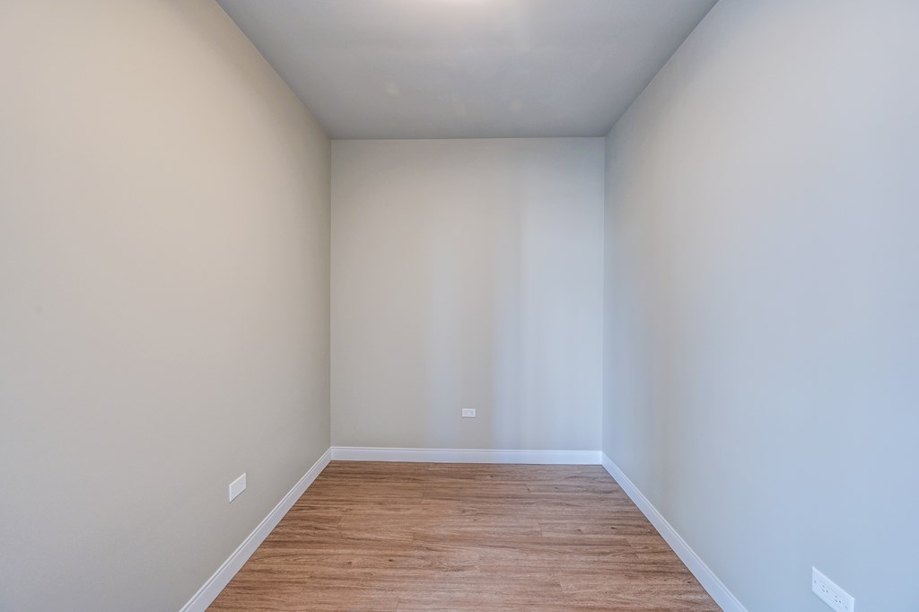 A room with wooden flooring and white walls.