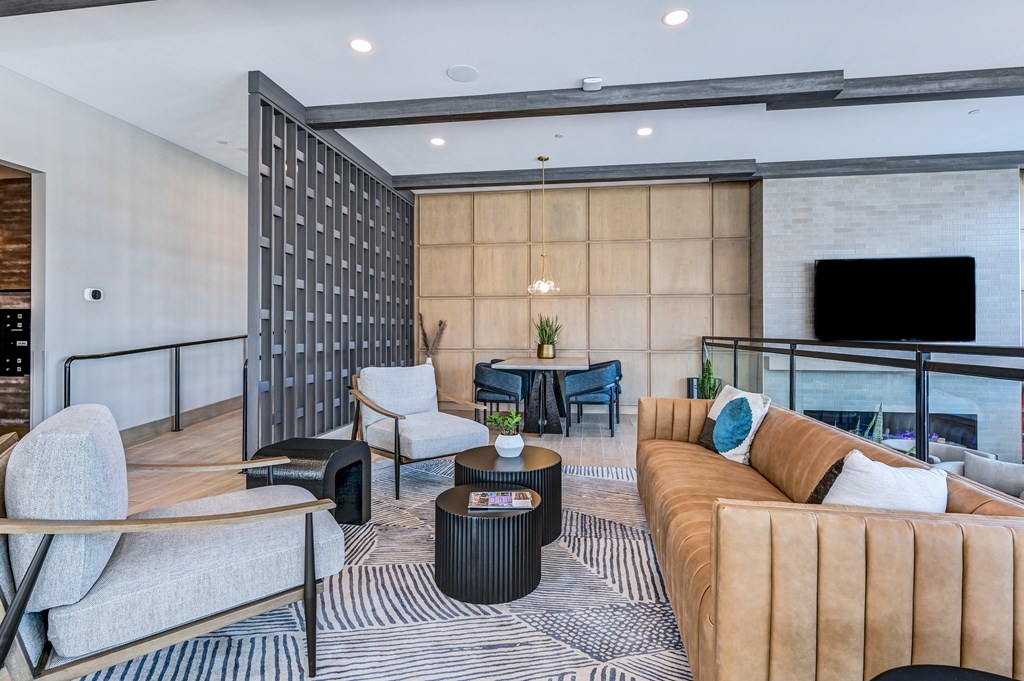 A modern living room with a large sofa, armchairs, and a coffee table.