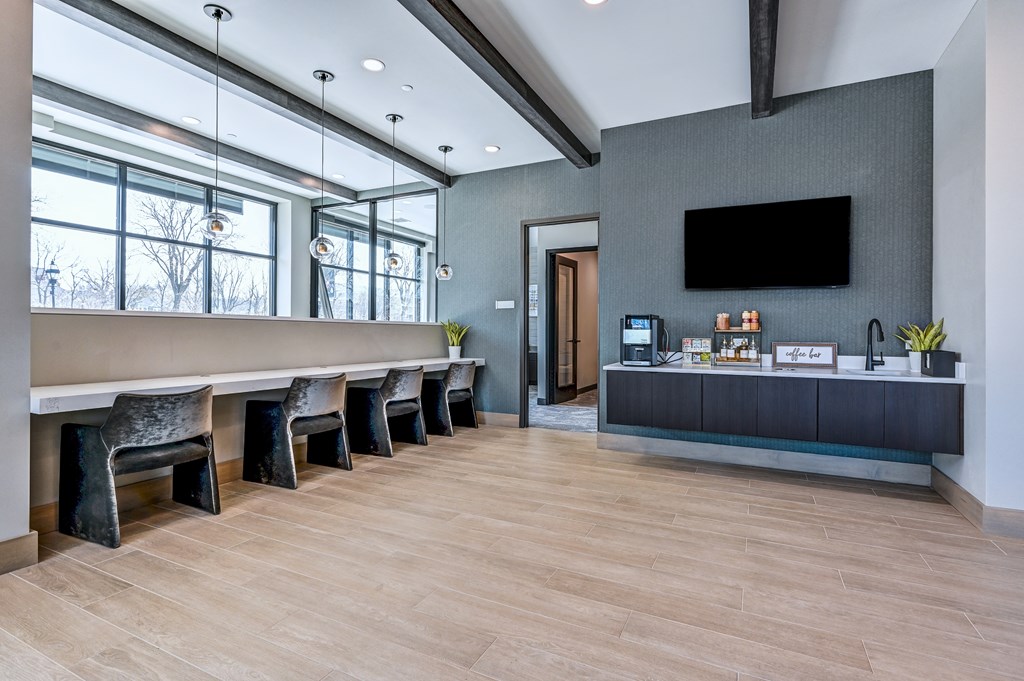 A modern room with a long table and chairs, a flat screen TV, and a cabinet with decorative items on top.
