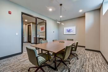 A conference room with a long table and chairs.