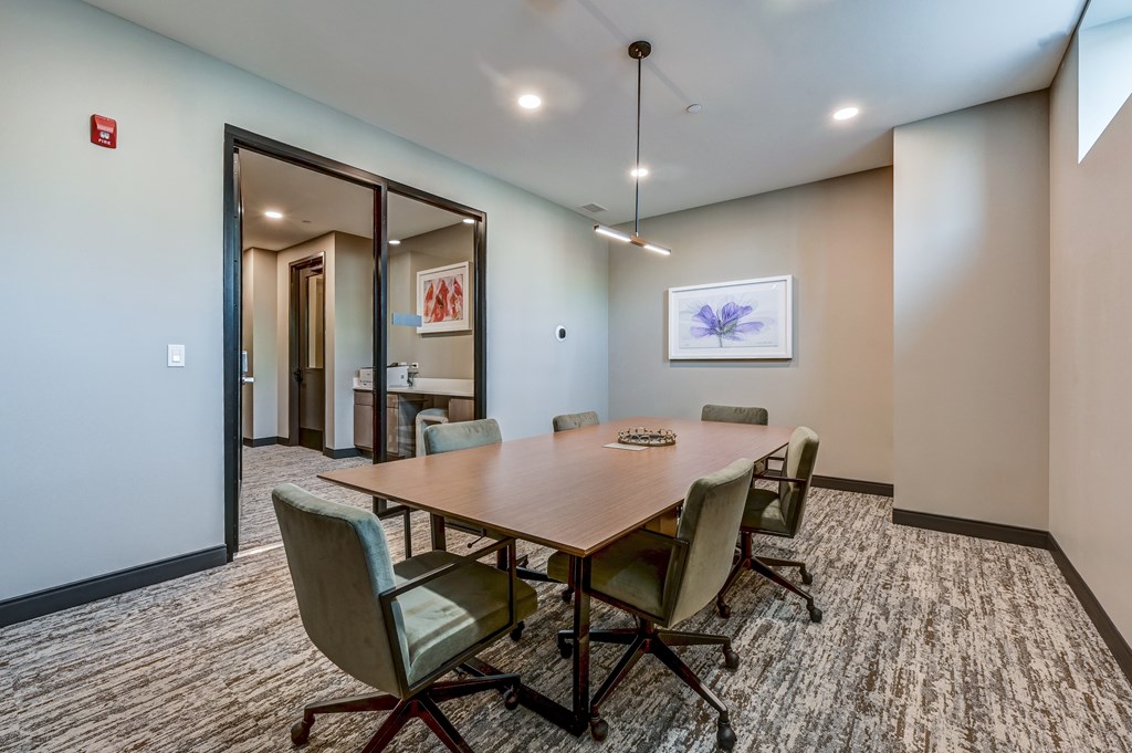A conference room with a long table and chairs.