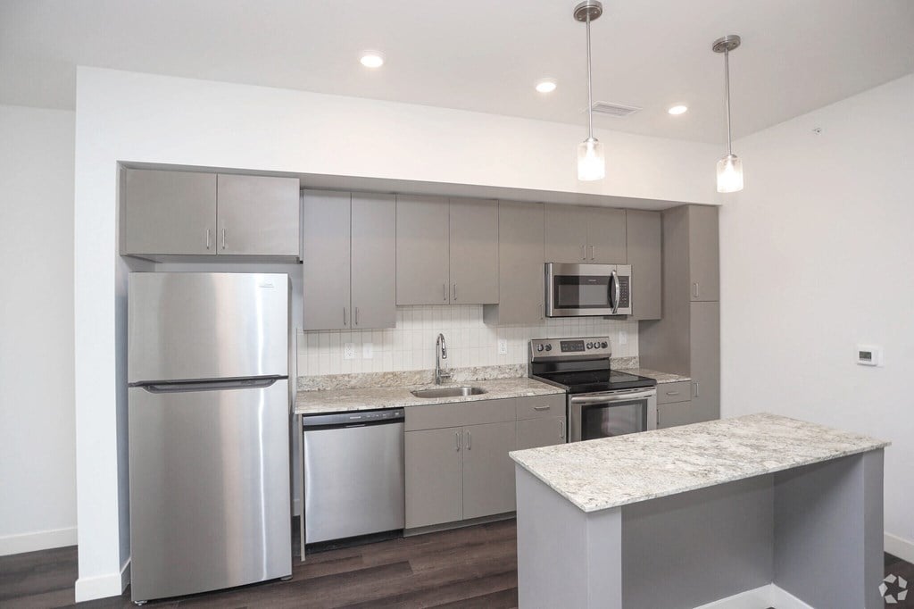 view of a kitchen with stainless steel appliances and island.