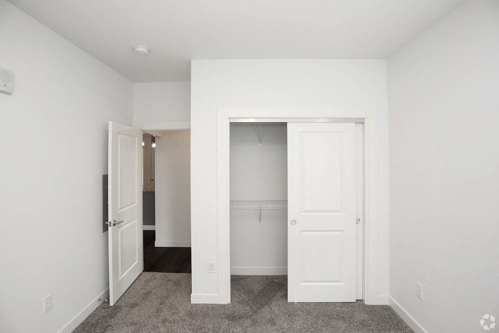 an empty room and view of closet doors