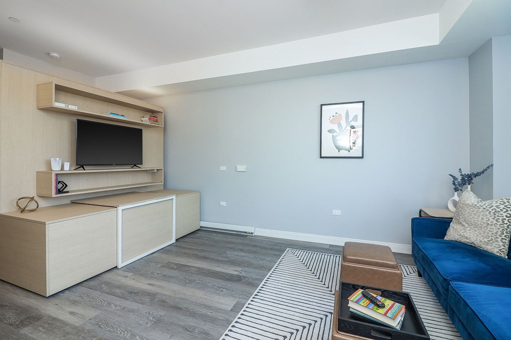 a living room with a blue couch and a television
