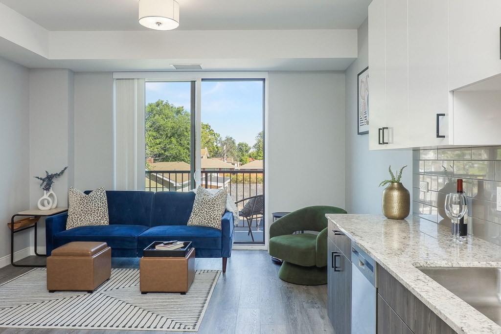 a living room with a blue couch and a kitchen counter