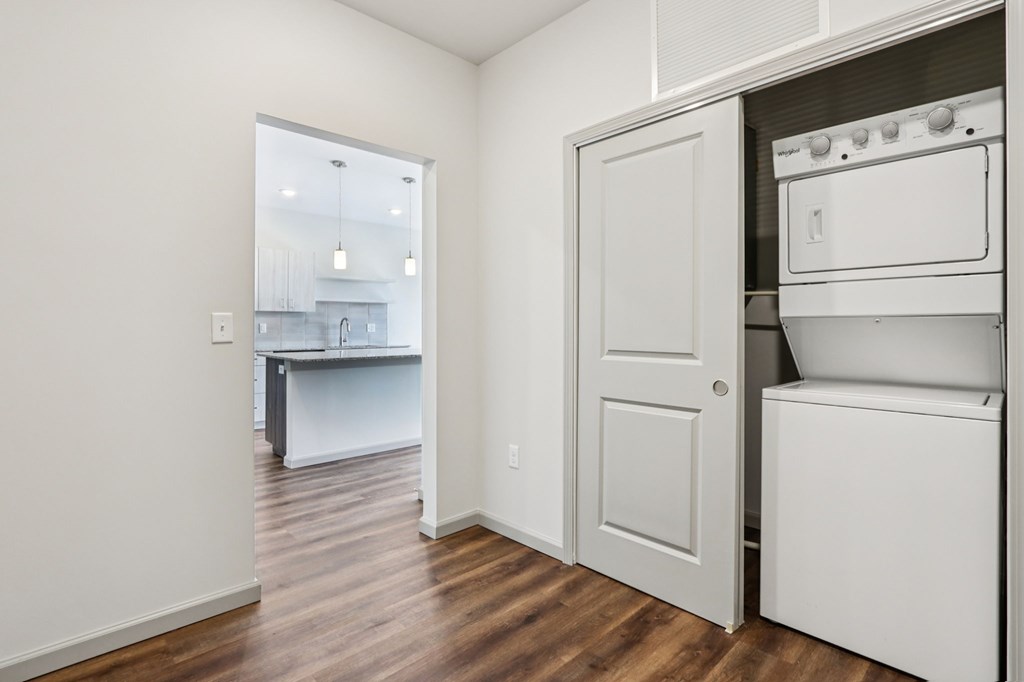 A white kitchen with a white oven and a white door.