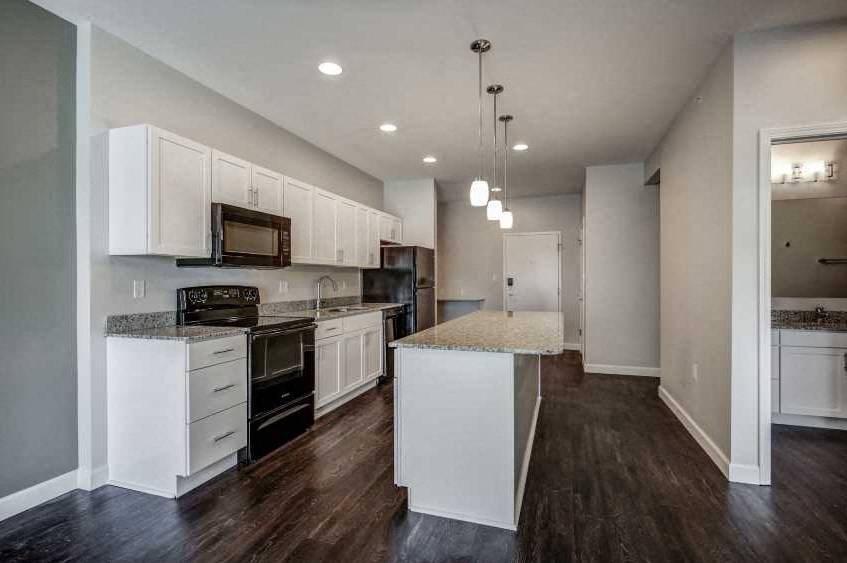 an empty kitchen with white cabinets and a counter top