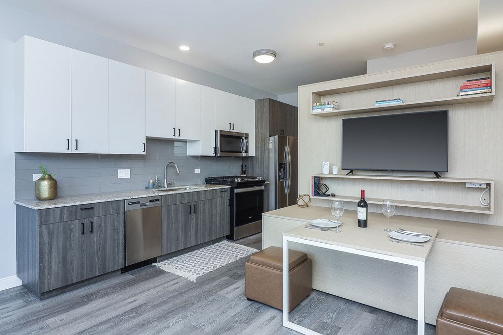 a kitchen and living room with a table and a television