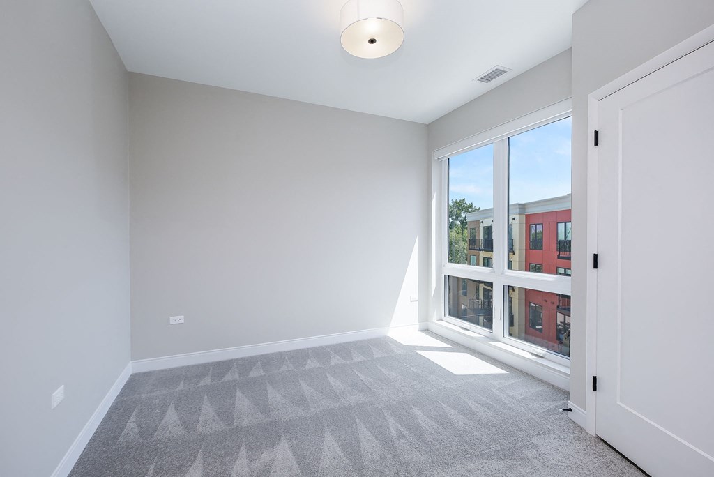 a living room with a large window and a carpet