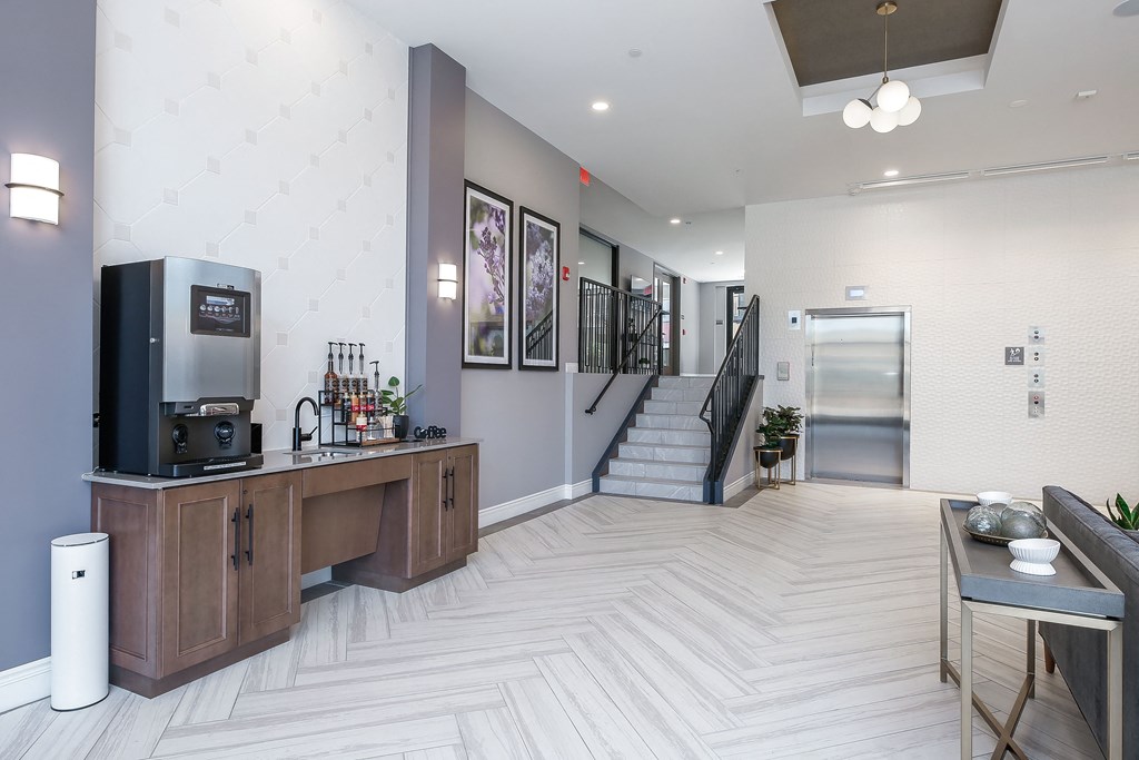 a resident lobby with a coffee bar and stairs to the second floor