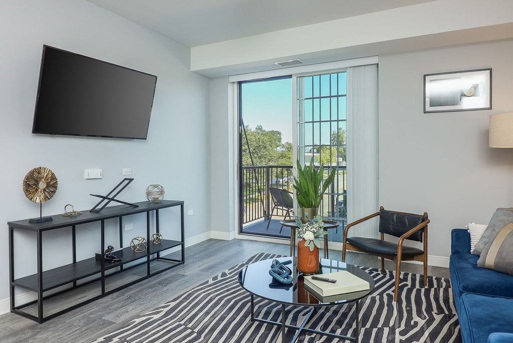 a living room with a blue couch and a coffee table and a television