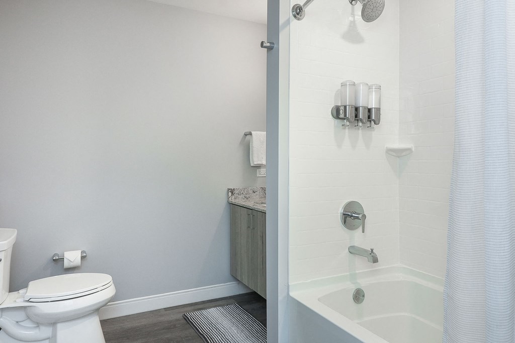 A white toilet sits next to a white sink in a small bathroom.