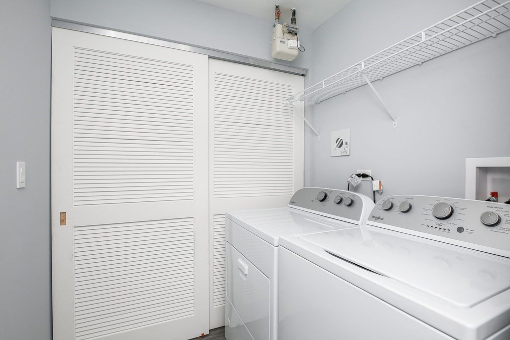 a white kitchen with a stove and a white closet