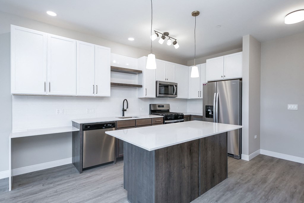 a modern kitchen with stainless steel appliances and white cabinets