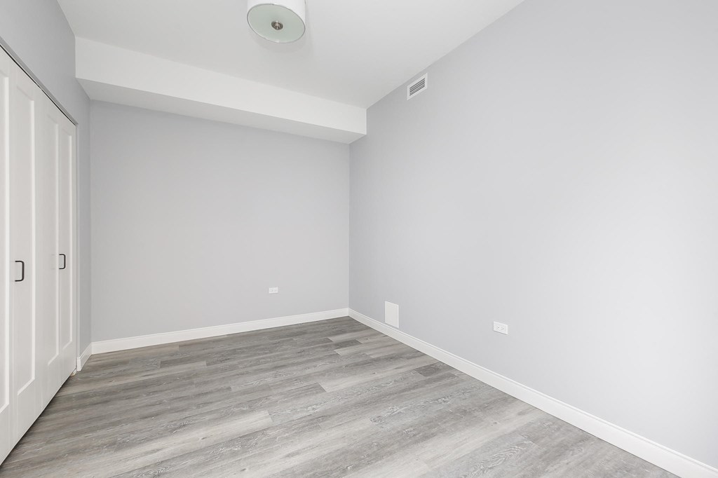 a empty room with white walls and wood floors