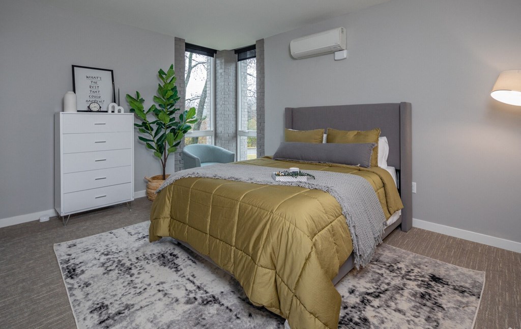 a bedroom with a bed and a dresser and a window