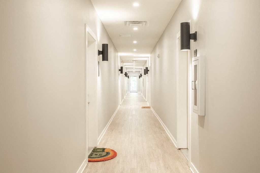a long hallway with white walls and white floors and white doors