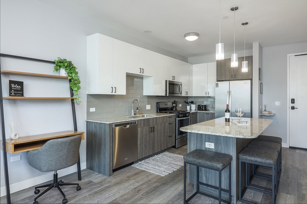 A kitchen with a bar stool and a chair.