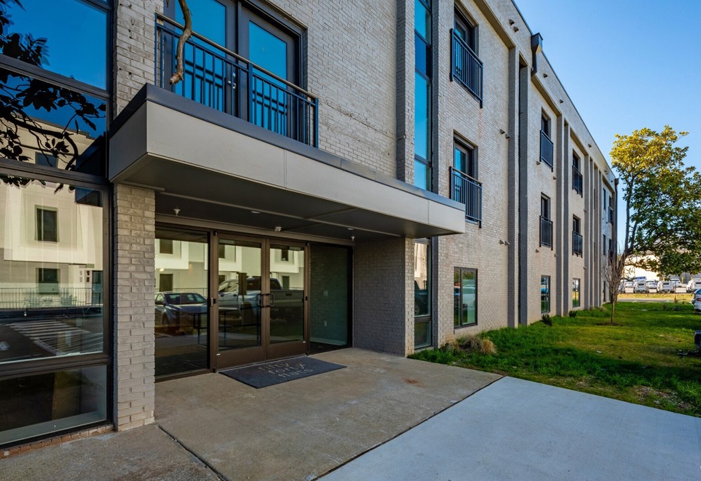 the entrance to a building with a sidewalk and glass doors
