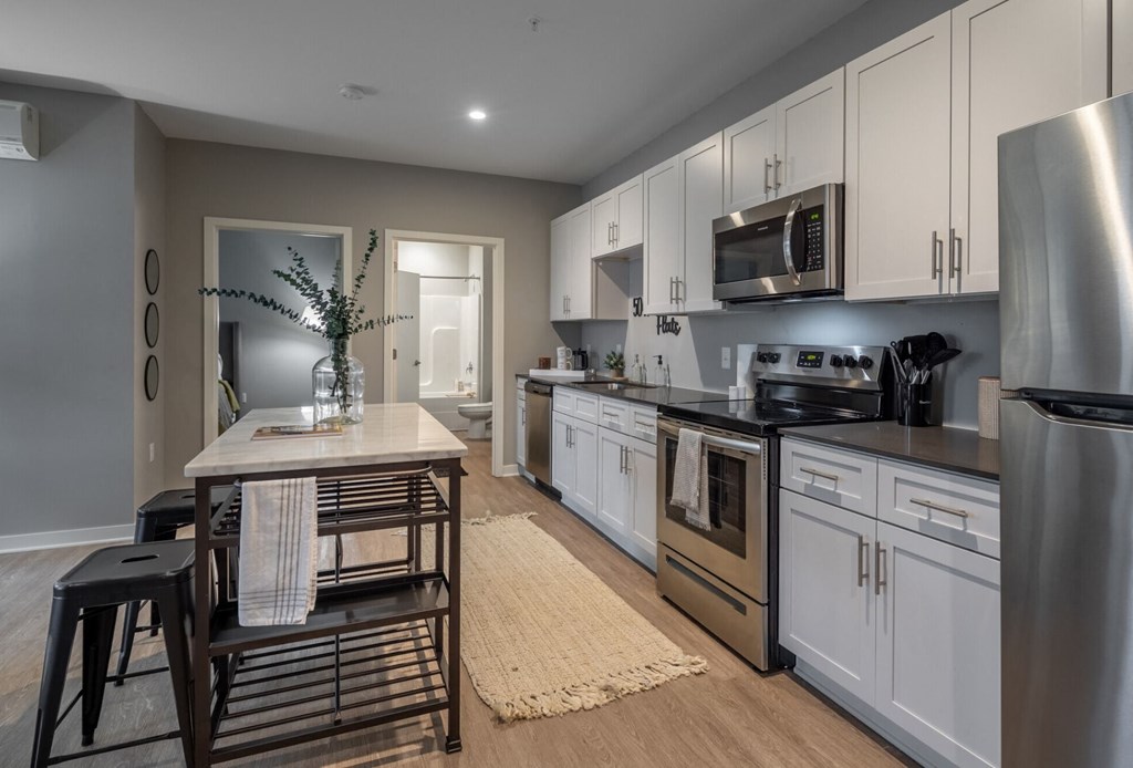 a kitchen with stainless steel appliances and a wooden table