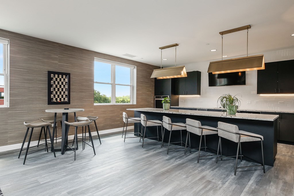 a kitchen with a bar and chairs and a table with stools