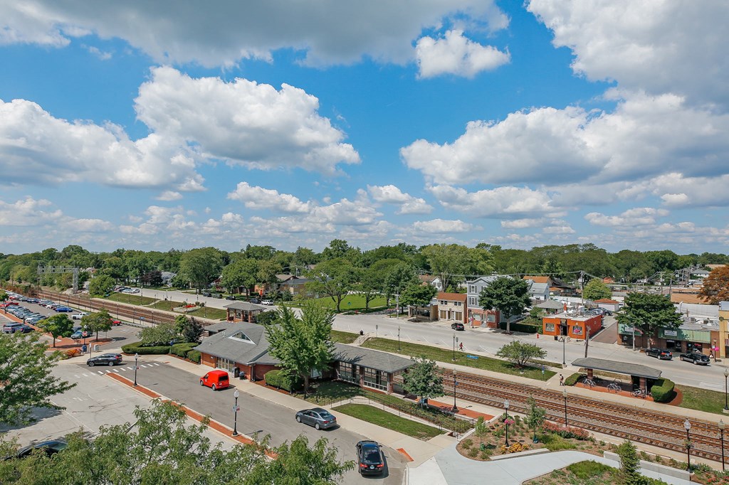 an aerial view of a city with train tracks and a parking lot