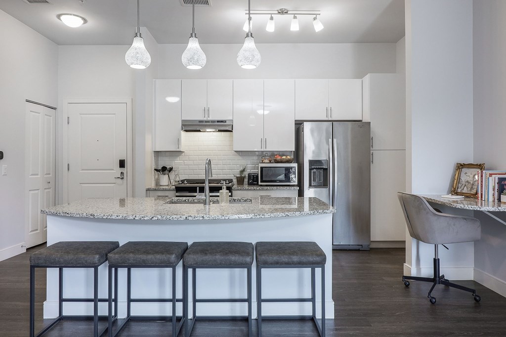 A kitchen with a bar and stools.