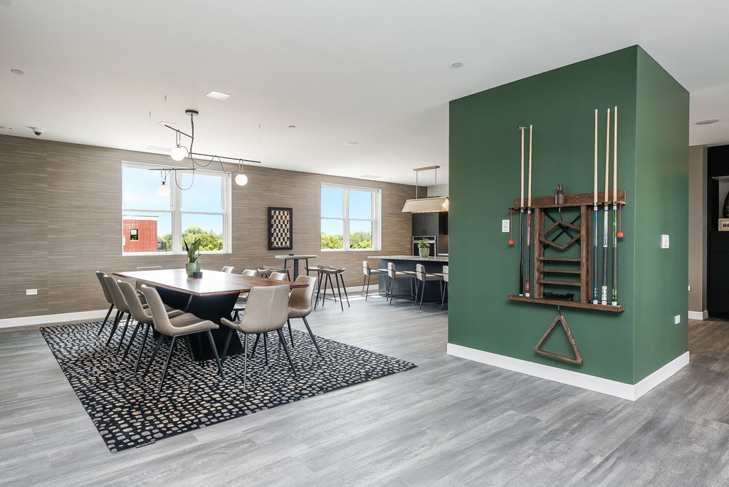 a dining room with a table and chairs and a green wall