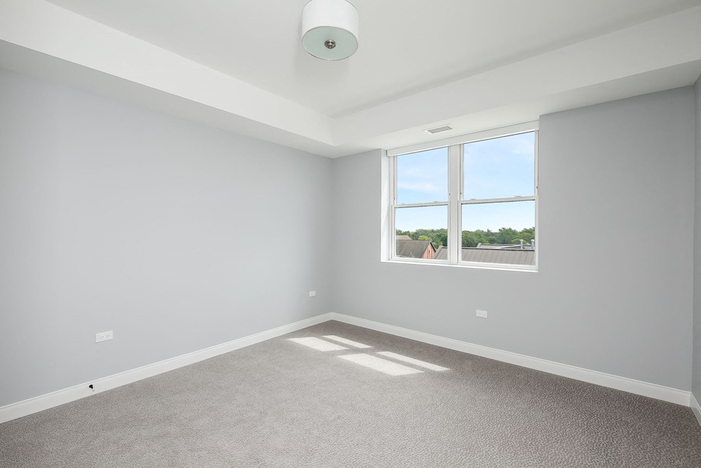 an empty room with a window and carpet