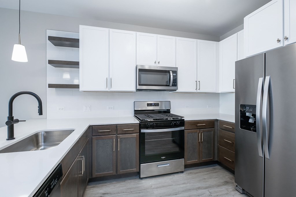 A modern kitchen with stainless steel appliances and white cabinets.