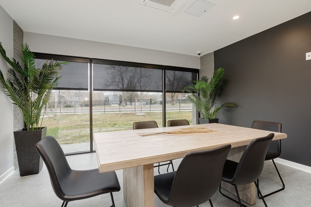 a dining room with a table and chairs in front of a window