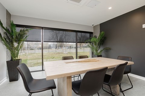 a dining room with a table and chairs in front of a window
