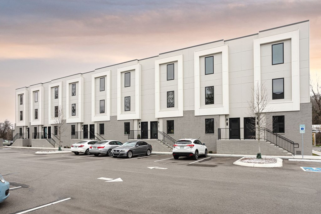 a large white building with cars in a parking lot
