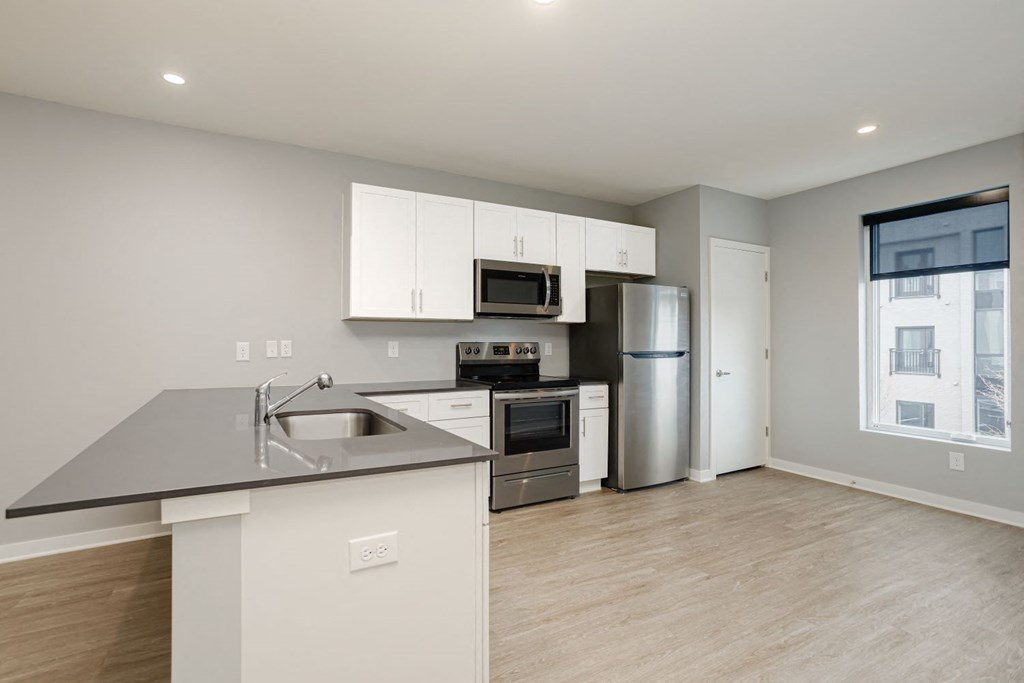 a kitchen with white cabinets and stainless steel appliances