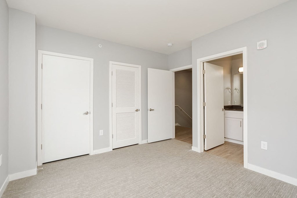 a bedroom with two closets and a door to a bathroom